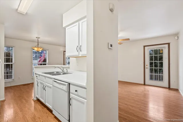a kitchen with a sink cabinets and wooden floor