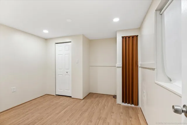a view of hallway with a large window and wooden floor