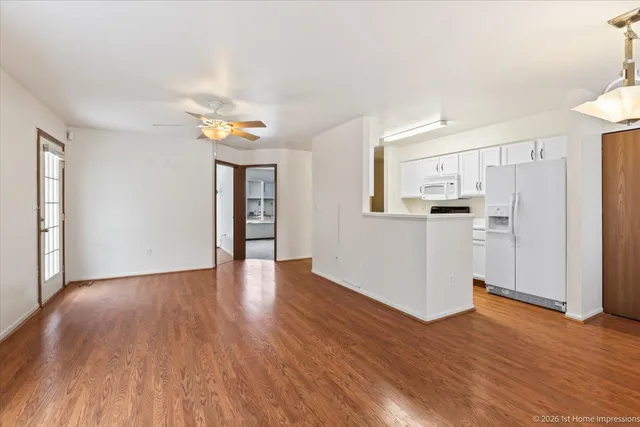 a view of a kitchen with wooden floor and a window