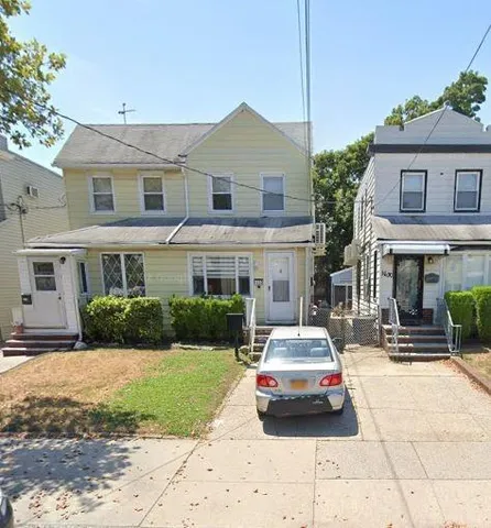 a car parked in front of a brick house