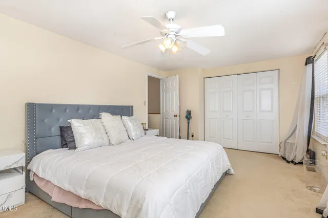 a bedroom with a large bed and ceiling fan
