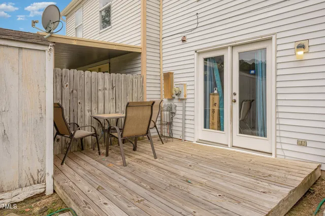 a view of a roof deck with table and chairs and wooden floor