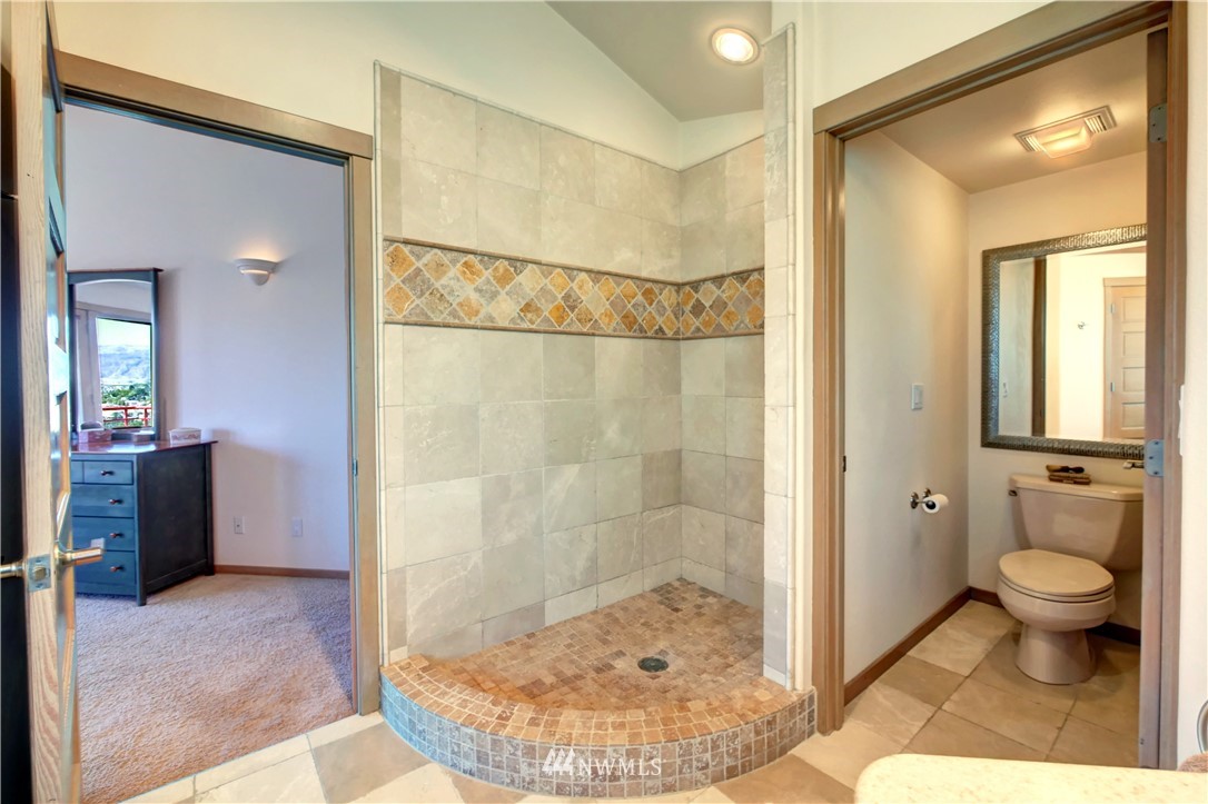 25 Black Road Omak, WA 98841 - Photo 23 of 38 a bathroom with a granite countertop sink a toilet and shower