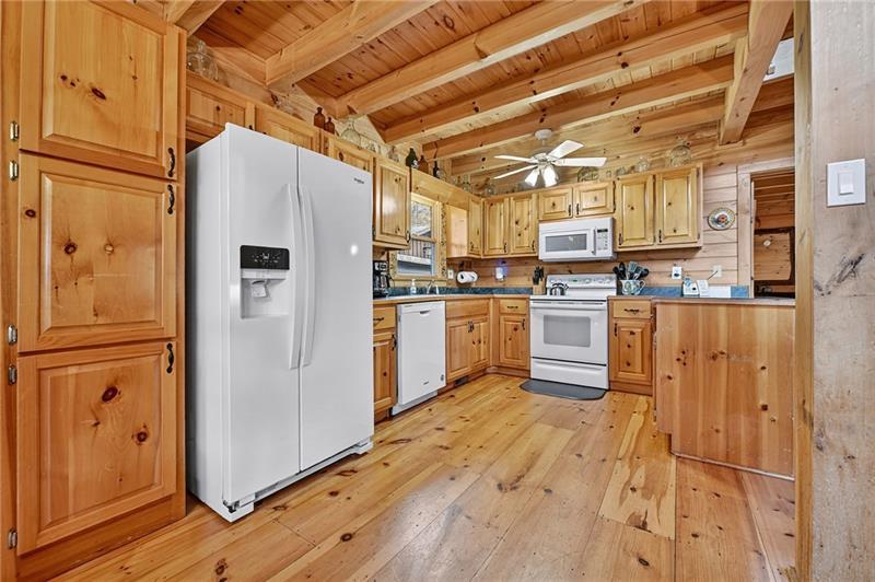 100 Arrow Way Mineral Bluff, GA 30559 - Photo 17 of 53 a kitchen with stainless steel appliances granite countertop a refrigerator a stove and white cabinets with wooden floors