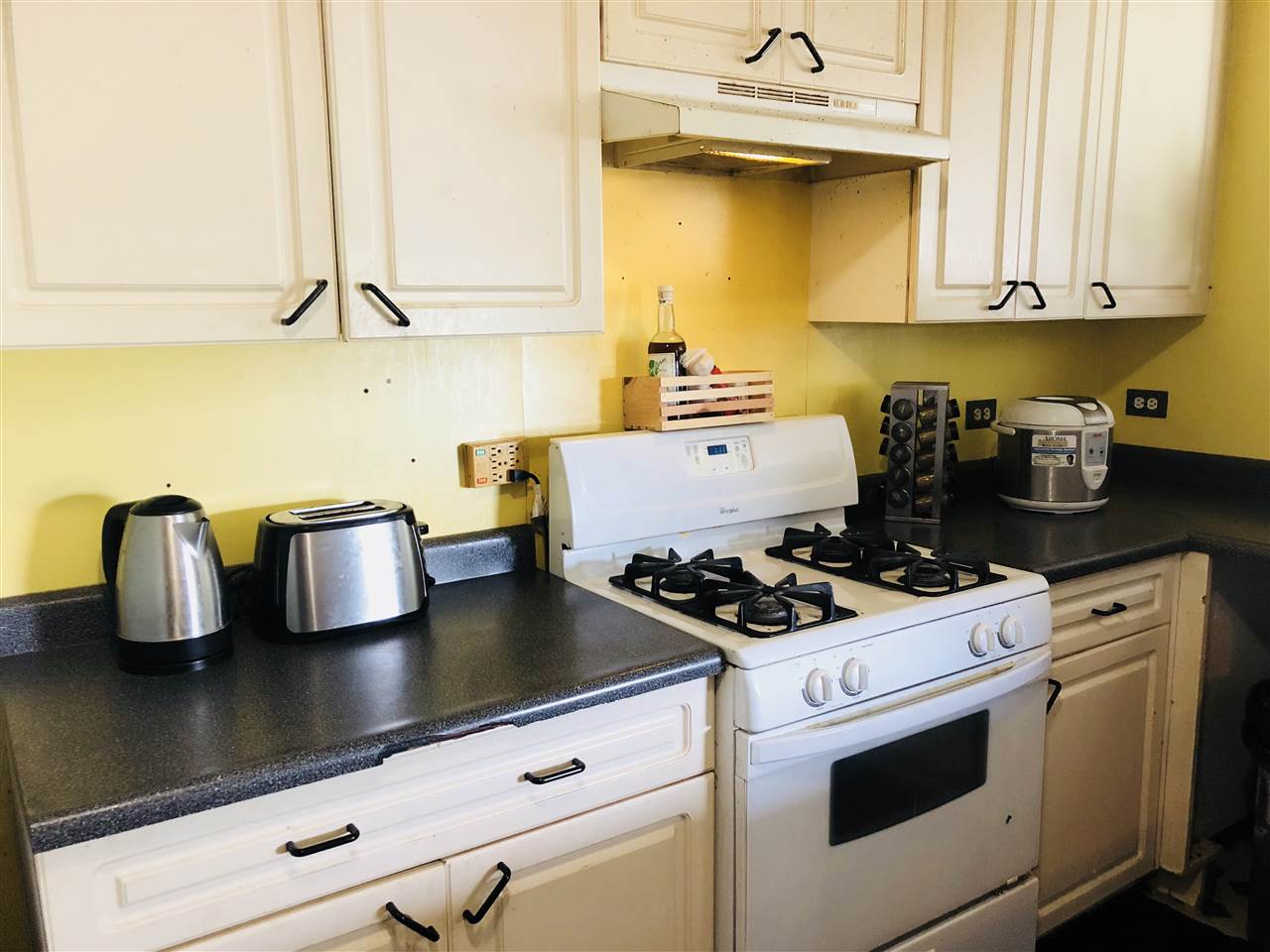 1752 West Kuiaha Road Haiku, HI 96708 - Photo 7 of 24 a kitchen with a stove and a white cabinets