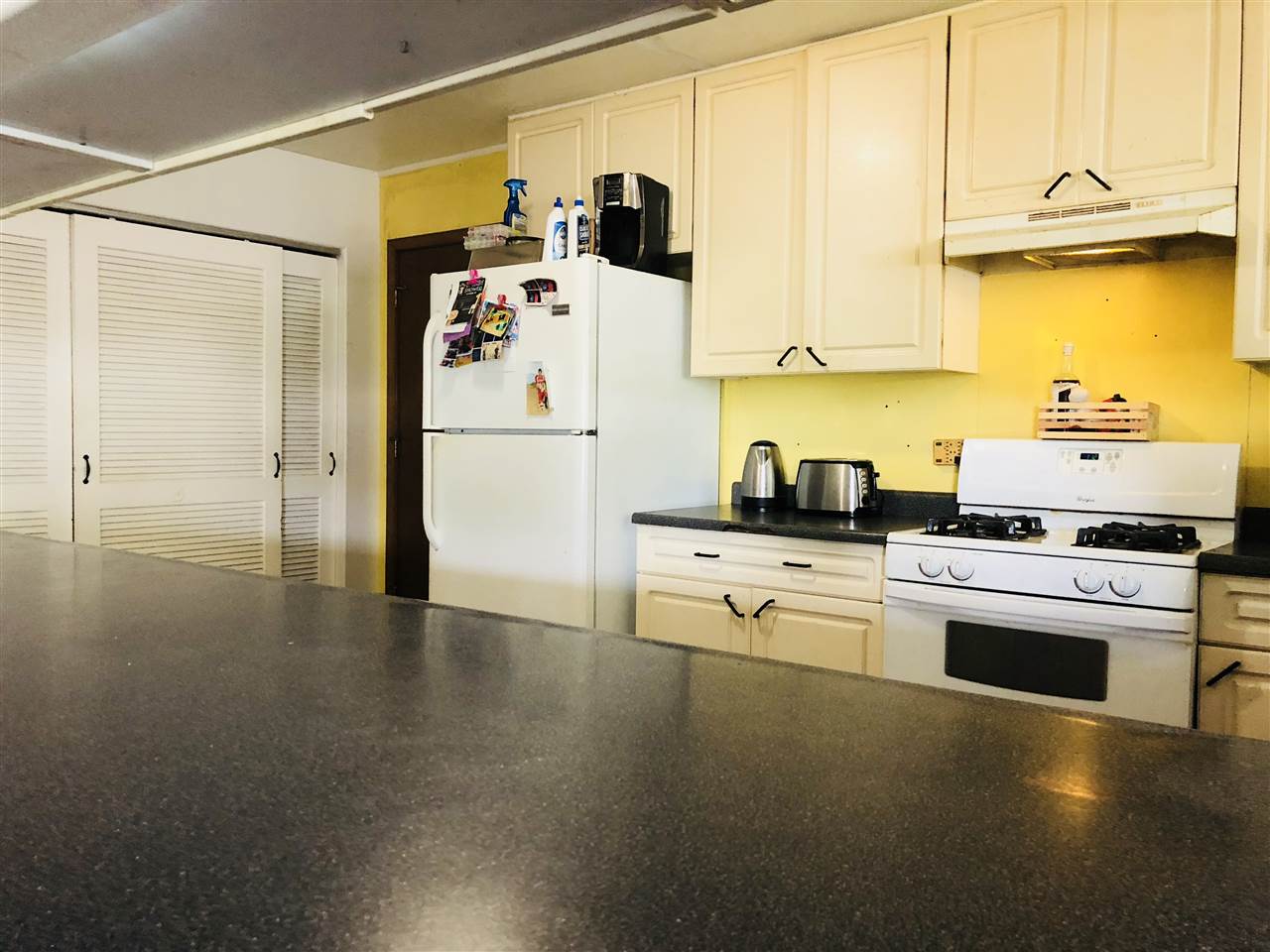 1752 West Kuiaha Road Haiku, HI 96708 - Photo 8 of 24 a kitchen with a refrigerator and a stove top oven