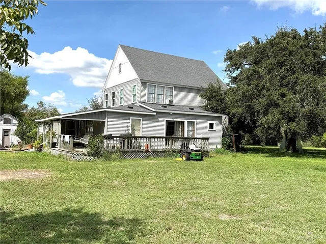 a view of a house with a big yard and sitting area