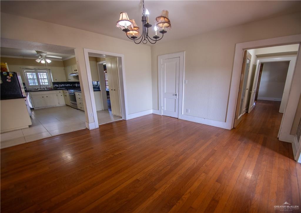 26717 Baker Potts Road Harlingen, TX 78552 - Photo 8 of 18 a view of an empty room with wooden floor and a kitchen