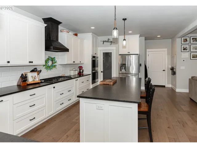 a kitchen with kitchen island granite countertop a sink a stove and cabinets