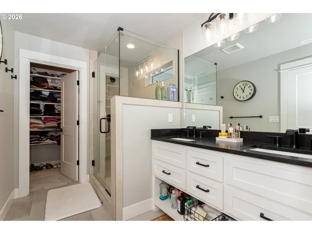 a kitchen with granite countertop a sink and a clock on the wall