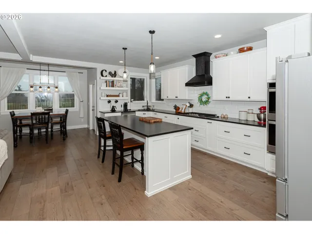 a kitchen with stainless steel appliances kitchen island granite countertop a sink and cabinets