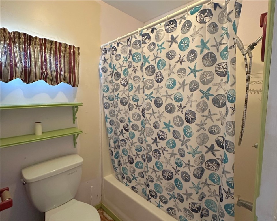 600 South Rachal Sinton, TX 78387 - Photo 15 of 17 a bathroom with a toilet and a shower curtain