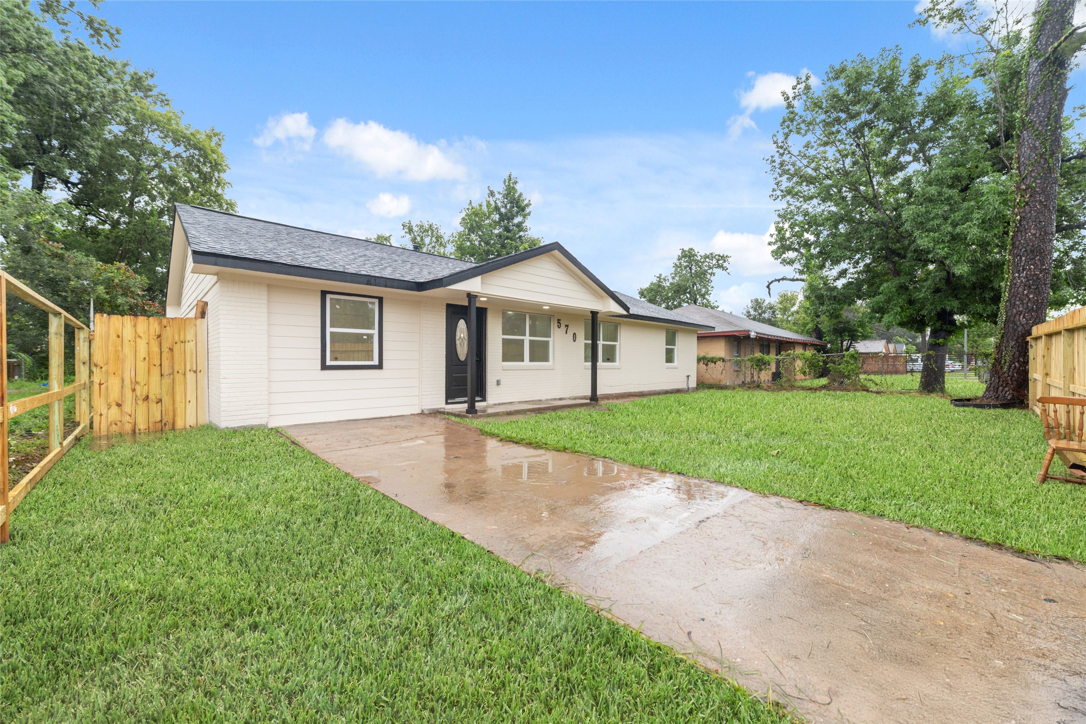 5709 Langley Road Houston, TX 77016 - Photo 26 of 27 Charming single-story home with a fresh, modern exterior. It features a spacious lawn, a concrete driveway, and a fenced yard, offering ample privacy and outdoor space. Perfect for comfortable living.