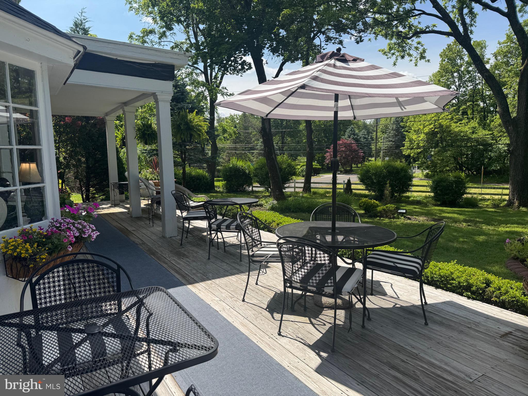 1324 River Road New Hope, PA 18938 - Photo 68 of 70 a view of a patio with table and chairs under an umbrella with a garden