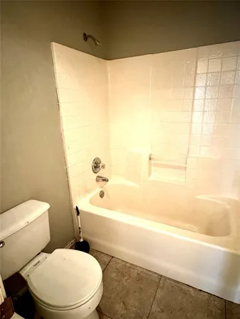 a white toilet sitting next to a bath tub