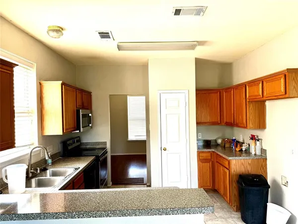 a kitchen with granite countertop a refrigerator and a sink
