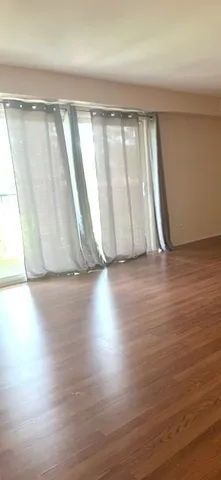 a view of room with window and wooden floor