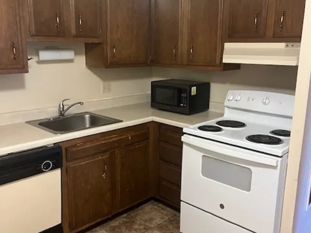 a kitchen with a sink stove and cabinets