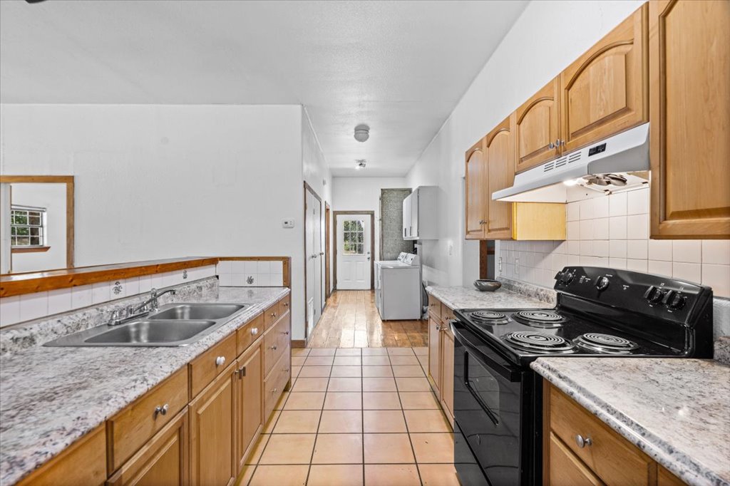 555 Harmon Hills Road, Unit A Dripping Springs, TX 78620 - Photo 16 of 29 A well-lit kitchen featuring dual sinks and an electric range, perfect for culinary endeavors.