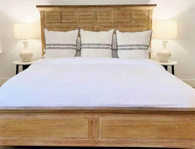 a living room with a couch and dresser with wooden floor