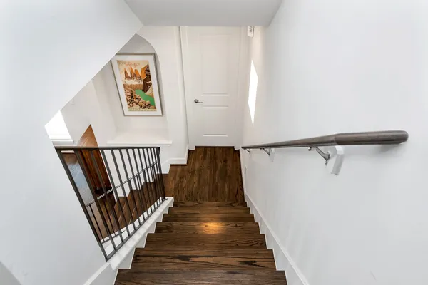 a view of a hallway with wooden floor and staircase
