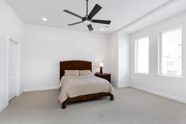 a bedroom with a bed a window and a painting