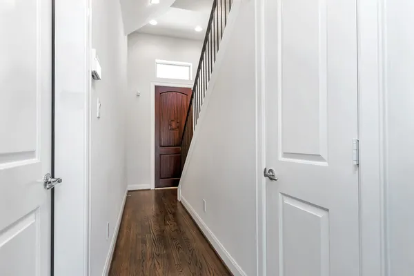 a view of a hallway with wooden floor and staircase