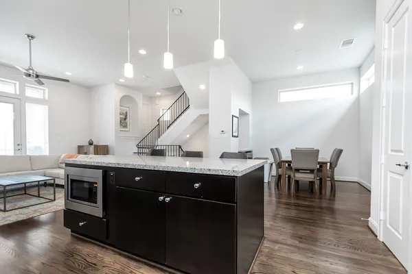 a kitchen with stainless steel appliances granite countertop a sink a stove and a wooden floors