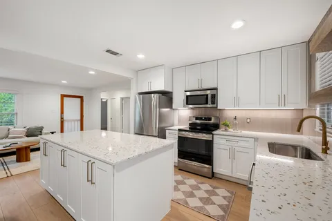 a kitchen with a dining table chairs refrigerator and cabinets