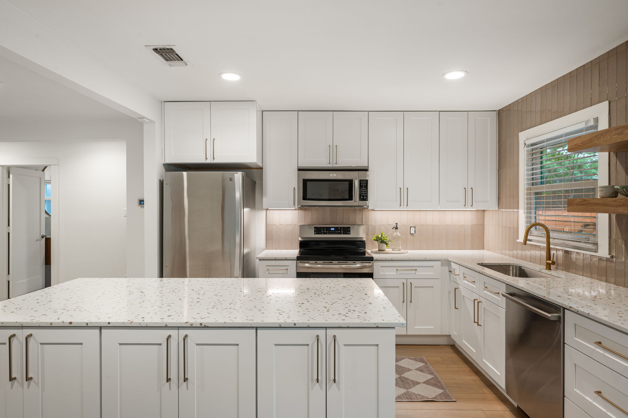 5506 Duval Street Austin, TX 78751 - Photo 12 of 38 a kitchen with a sink a microwave a refrigerator and cabinets