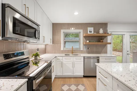 a kitchen with a sink a microwave a refrigerator and cabinets