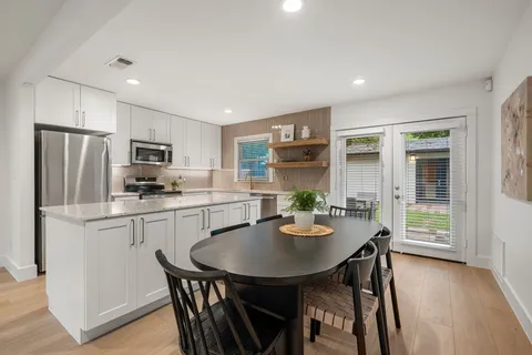 a living room with stainless steel appliances kitchen island granite countertop furniture and wooden floor