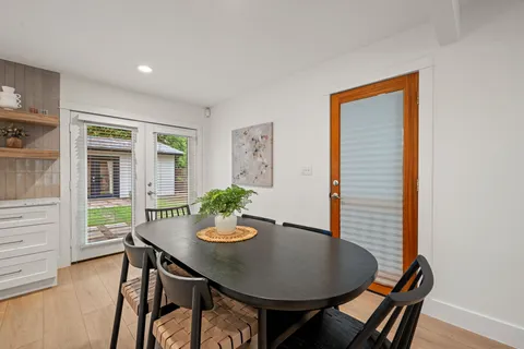 a kitchen with refrigerator a sink dining table and chairs