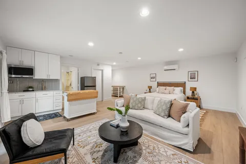 a living room with furniture a rug and kitchen view