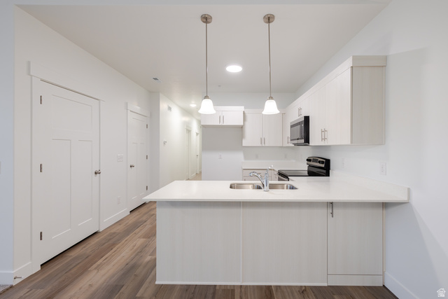 4661 Poplar Way, Unit R304 Mapleton, UT 84664 - Photo 14 of 17 Kitchen featuring a peninsula, light countertops, stainless steel appliances, and dark wood-style flooring