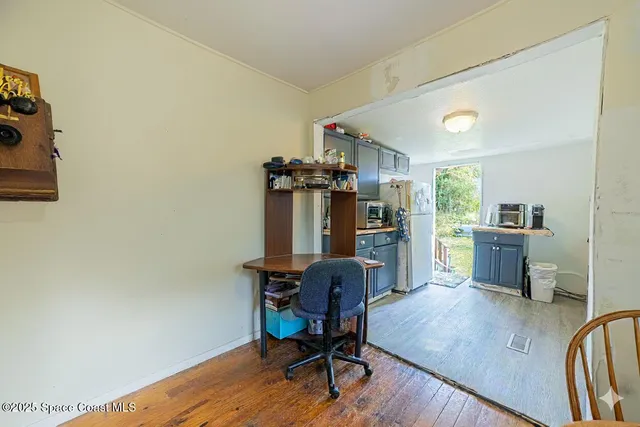 a view of a workspace with furniture and wooden floor