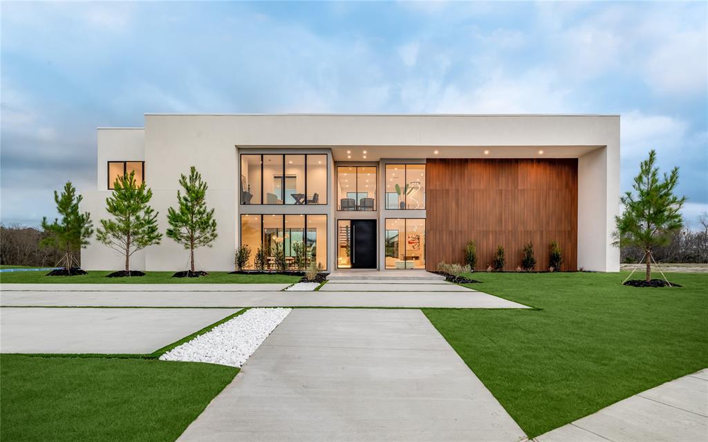 a front view of a house with a yard and potted plants