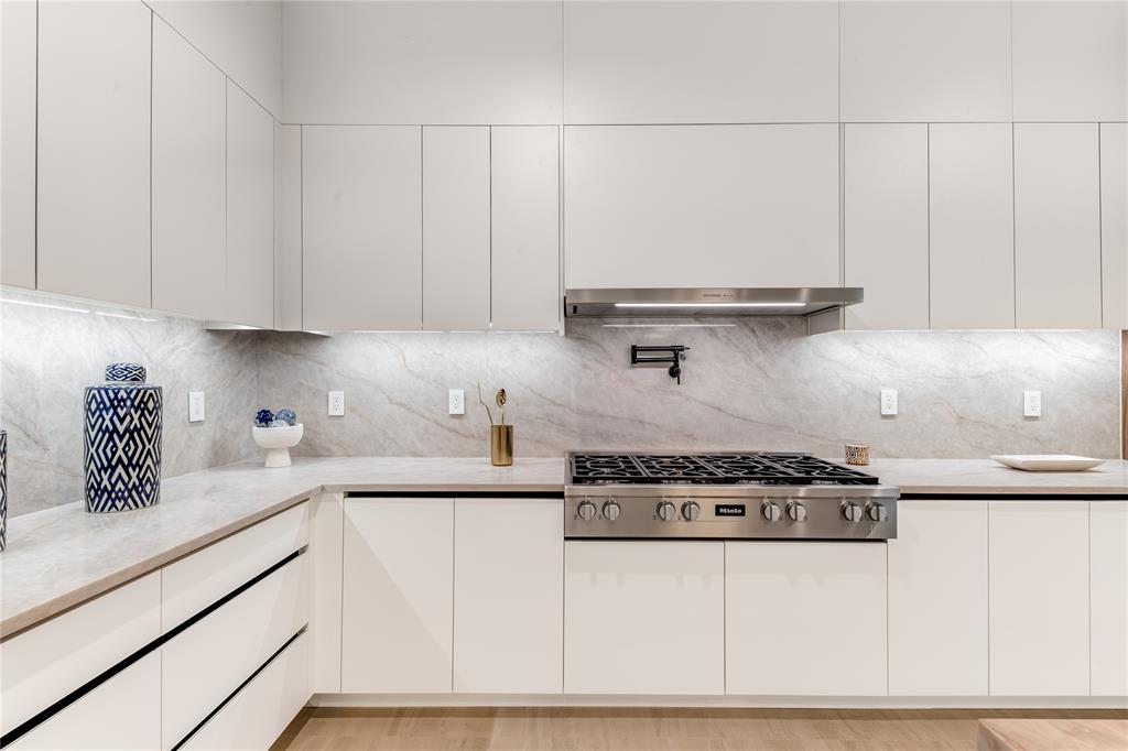 229 Sunset Pt Trail Heath, TX 75032 - Photo 11 of 40 a kitchen with stainless steel appliances granite countertop white cabinets and a stove