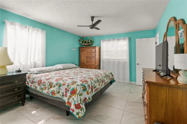 a bedroom with a bed dresser and a large window