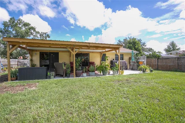 a view of a house with backyard porch and sitting area