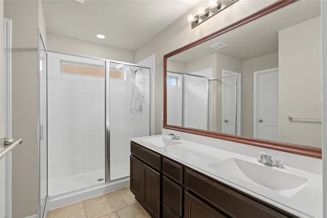 a bathroom with a double vanity sink and mirror