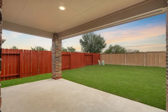 a view of a backyard with wooden fence