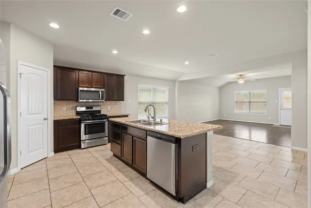 a kitchen with stainless steel appliances granite countertop a stove and a sink