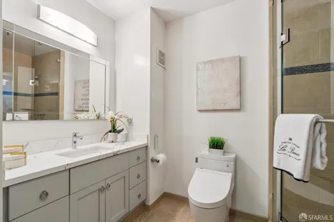 a bathroom with a toilet sink and mirror