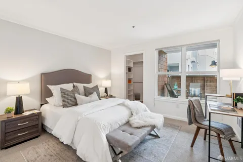 a bedroom with a bed and a large window