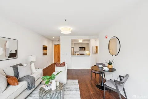 a living room with furniture a table and wooden floor
