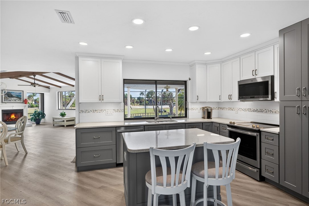 1312 Par View Drive Sanibel, FL 33957 - Photo 1 of 45 a kitchen with stainless steel appliances granite countertop a kitchen island hardwood floor sink stove dining table and chairs