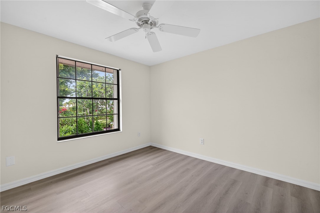1312 Par View Drive Sanibel, FL 33957 - Photo 21 of 45 an empty room with wooden floor fan and windows