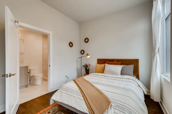 a bedroom with a bed and wooden floor