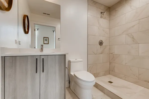 a bathroom with a shower a toilet and sink